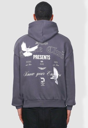Grauer Hoodie mit lockerer Passform, der auf der Rückseite weiße Grafiken von Vögeln und Text zeigt. Enthält eine Kängurutasche und gerippte Bündchen.