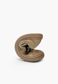 Chaussure en daim marron flexible pliée en deux pour démontrer sa semelle et son matériau souples et flexibles sur fond blanc.