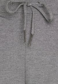 Grå sweatpants er lavet af et tekstureret stof, har en snoretræk i livet med metalliske aglets og glatte sømme for ekstra komfort.