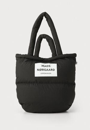 Black puffer tote bag with dual top handles, featuring a white logo label. Soft, quilted texture with rounded base and smooth seams.