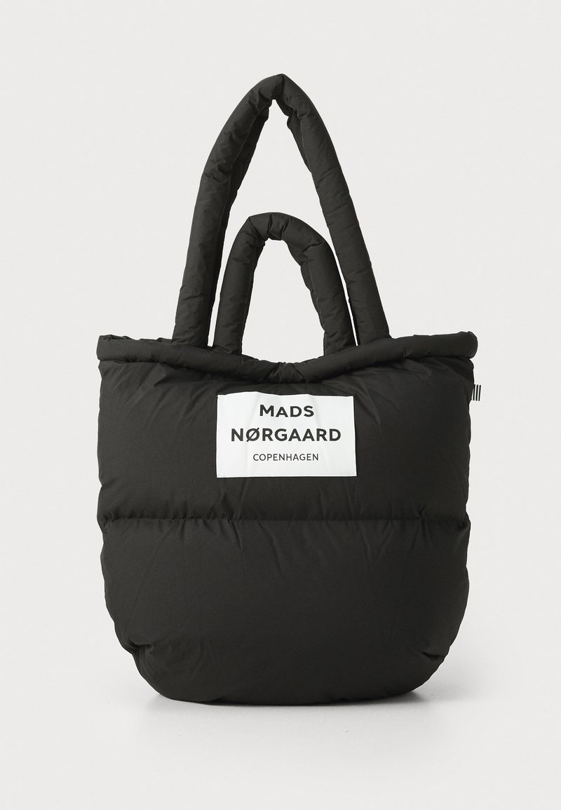 Sac fourre-tout noir en duvet avec deux poignées supérieures, arborant une étiquette logo blanche. Texture douce, matelassée avec un fond arrondi et des coutures lisses.