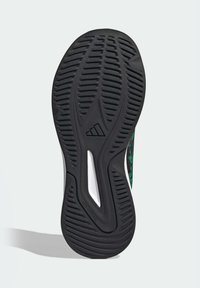 Czarna podeszwa sportowego buta z teksturowanym wzorem chwytu i białym akcentem. Posiada niebrudzącą konstrukcję, zoptymalizowaną pod kątem przyczepności.