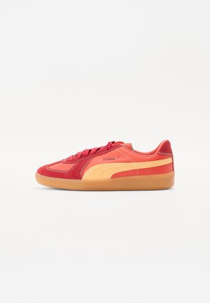 Baskets rouges et orange en suède et cuir ; dotées d'une semelle en gomme, d'accents texturés et d'un logo jaune contrastant.