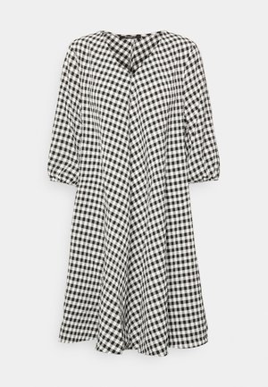Vestido midi de cuadros vichy en blanco y negro con mangas abullonadas hasta tres cuartos y escote redondo.