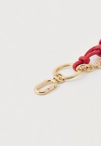 Κόκκινο δερμάτινο λουράκι με χρυσό μεταλλικό κλιπ για μπρελόκ και κυκλικό δαχτυλίδι, με λείο υφή και εμφανές κόμπο.