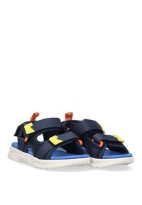 Sandalias azul marino con acentos amarillos y naranjas. Fabricadas en malla y materiales sintéticos. Cuentan con correas de velcro y suelas de goma blanca.