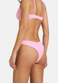 Rožnata rebrasta bikinija vključuje bralet z nastavljivimi naramnicami in zaponko, par visoko izrezanimi spodnjimi deli.