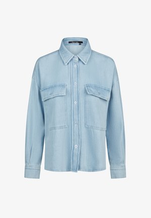 Light blue denim button-up shirt with long sleeves, pointed collar, and two large flap chest pockets with buttons.