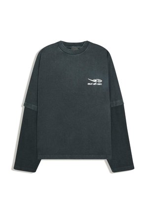 Tmavosivá svetrová košeľa s dlhým rukávom, s rebrovanými vnútornými rukávmi a bielym logom "out of care" na ľavej strane hrudníka.