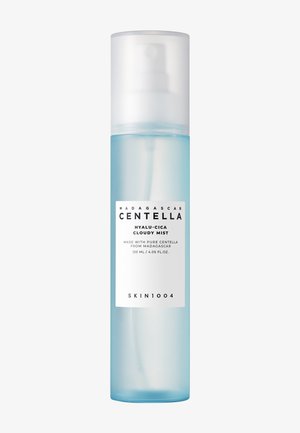 Klar, cylindrisk sprayflaske med et gradientblåt design. Har en hvid pumpe og en tydelig etiket med produktinformation.