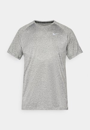 Camiseta atlética gris de manga corta con cuello redondo y un acabado texturizado; presenta un pequeño logo blanco de Nike en la parte izquierda del pecho.