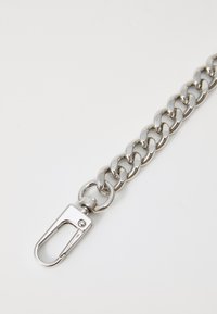 Sølvmetallkjede med store runde lenker og en svingbar krabbe-lås. Glatt tekstur med en skinnende finish.