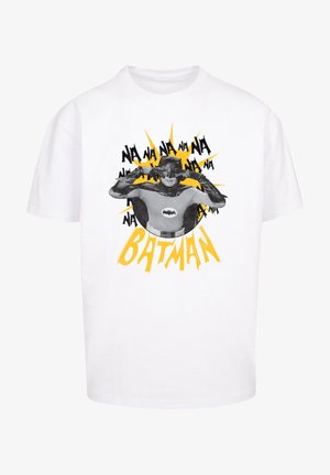 Biała bawełniana koszulka z graficznym nadrukiem postaci w czarnej masce i pelerynie, z żółtymi akcentami eksplozji i napisem "BATMAN."