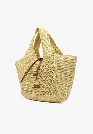 Sac fourre-tout en paille tissée avec larges anses et fermeture par cordon en cuir, avec une petite étiquette de marque rectangulaire à l'avant.