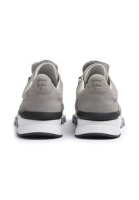 Sneakers in suede grigio con superficie testurizzata, dotati di una suola bianca e nera e un tallone accentuato. Logo F impresso sul retro.