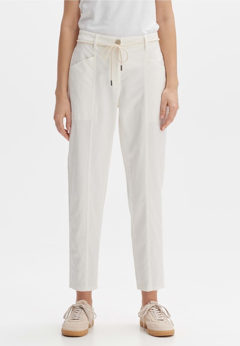 Witte katoenen broek in een katoenmix met een koordje in de taille, zijzakken, een taps toelopend ontwerp en een gemêleerde stof, gecombineerd met lichtgekleurde sneakers.