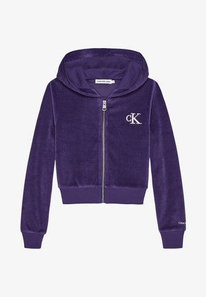 Fioletowy welurowy hoodie na zamek błyskawiczny z kapturem, ściągaczami przy mankietach i dolnym wykończeniu. Posiada białe haftowane logo na klatce piersiowej. Miękki, teksturowany materiał.