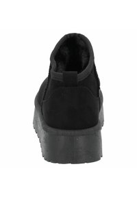Černé kotníkové boty s hladkým semišovým povrchem, zaoblenou špičkou a texturovanou gumovou podrážkou. Vyznačují se měkkým vnitřním podšíváním a poutkem na patě.