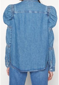 Denim blouse featuring puffed sleeves with gathered detailing. Light blue color, classic collar, and button closures at the cuffs. Casual fit.