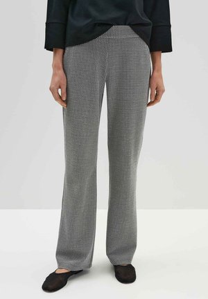 Pantaloni grigi e neri con una vestibilità slim e gambe dritte, realizzati in tessuto intrecciato. Abbinati a calzature nere.