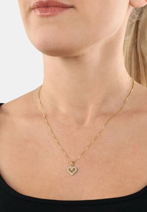 Collar de tono dorado con un colgante en forma de corazón, acentuado con pequeñas piedras claras. El colgante presenta un detalle de corazón en su interior.