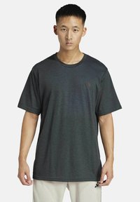 Heren T-shirt met korte mouwen in donkergrijs met een ronde hals, gemaakt van een geweven stof. Heeft een subtiele logo op de borst.