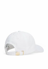 Cappellino da baseball bianco in cotone con visiera curva. Presenta una fibbia metallica dorata e un bottone sulla corona. Cinghia di regolazione posteriore.