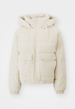 Beige kordflöjls pufferjacka med dragkedja fram, huva och två framfickor i lappar. Har ribbad textur och elastiska muddar.