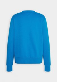 Sudadera azul con un cuello redondo clásico, puños y bajo acanalados. Textura suave, color liso y sin patrones niaccesorios visibles.