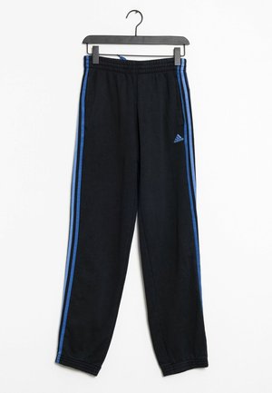 Černé tepláky Adidas s modrými pruhy po stranách a elastickým pasem, zavěšené na černém ramínku na bílém pozadí.