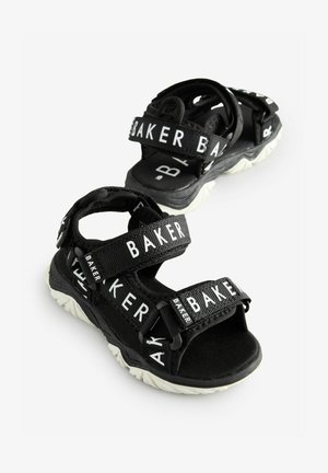 Fekete sport szandálok, texturált pántokkal, rajtuk "BAKER" felirattal, párnázott talppal és fehér gumitalppal. Állítható tépőzáras rögzítéssel.