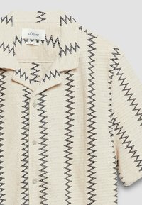 Chemise crème à manches courtes avec motif zigzag noir, boutonnière devant et col à revers, marque s.Oliver.