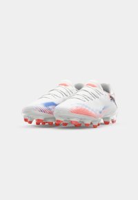 White football cleats with a textured upper featuring pink and blue gradient accents. Transparent sole with red studs for traction.