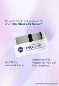 White cream jar with a silver lid, labeled "NIVEA CELLULAR" and "EXPERT FILLER." Text includes SPF 30 and anti-aging benefits. Smooth surface.