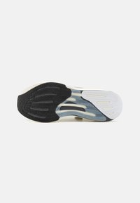 Shoe sole featuring a three-part design with black rubber, gray and white patterns, and textured grooves for traction.
