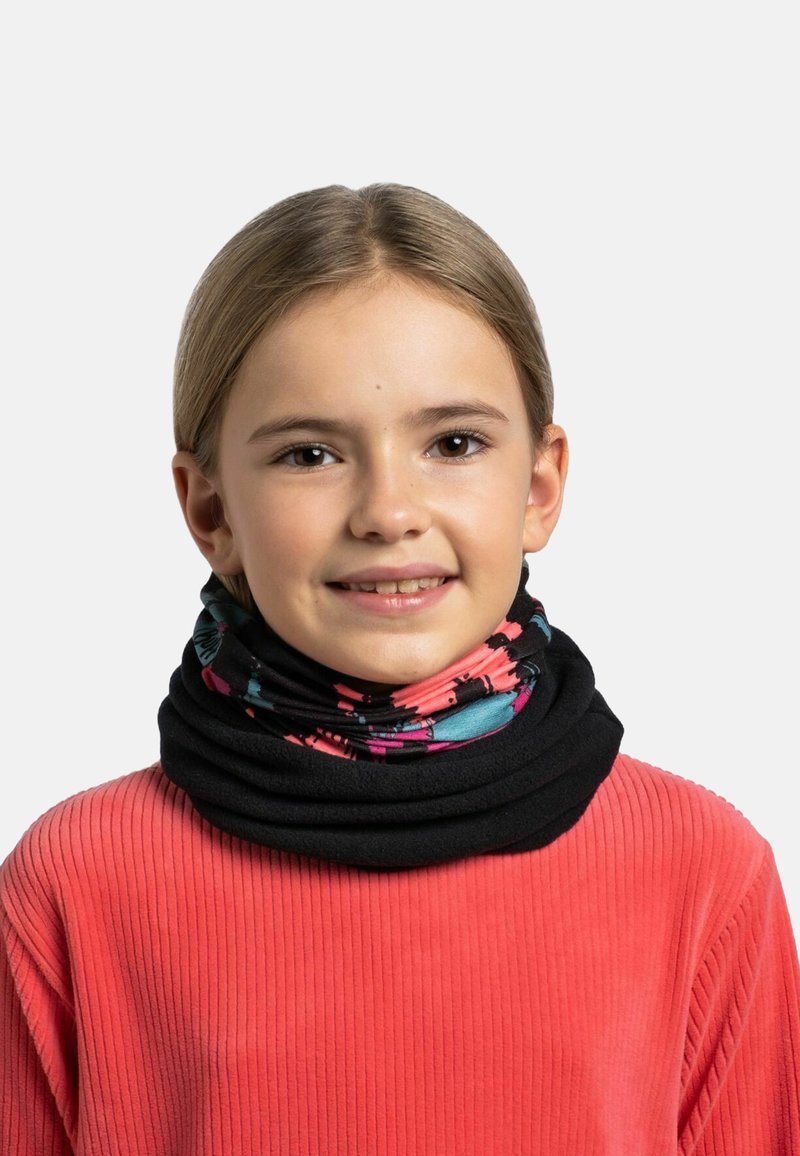 Cuello de tortuga negro con un colorido patrón floral en rosa y azul. Suéter de coral acanalado llevado debajo. Textura de tela suave.