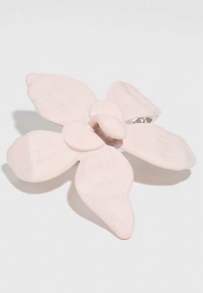 Pink flower-shaped hair clip with glossy finish, featuring five petal-like elements and a clip mechanism on the back.