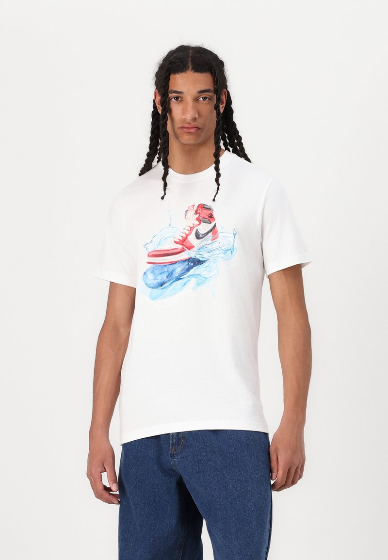 Hvid bomulds-t-shirt med et farverigt grafik af en sneaker på vand, rund halsudskæring, korte ærmer og en afslappet pasform.