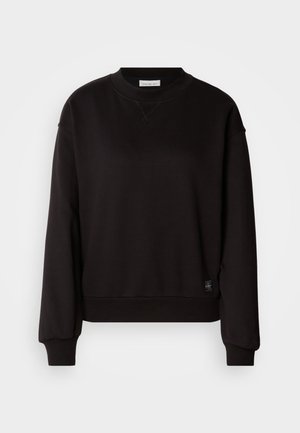 Sweatshirt preto feito de tecido suave, com gola redonda, mangas longas e punhos canelados. Apresenta uma pequena etiqueta de logotipo na bainha.