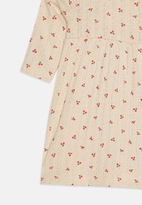 Knee-langes, beiges Kleid mit einem strukturierten Muster und kleinen roten Kirschmotiven. Es hat kurze Ärmel und ein faltiges Rockdesign.