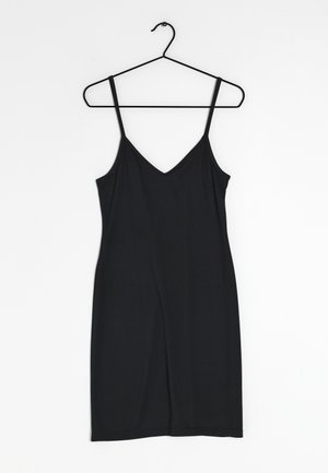 Robe noire sans manches avec fines bretelles, design enV, fabriquée en tissu doux, avec une silhouette ajustée et une longueur au genou. Suspendue à un crochet noir.