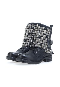 Čierne kožené členkové topánky s plochými opätkami, s kovovými cvokmi rôznych tvarov na vrchnej časti. Detaily šnurovania a postranný prackový akcent.
