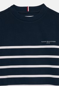 Felpa navy con strisce orizzontali bianche e scollo a girocollo a costine. Presenta un piccolo logo bianco sul davanti.