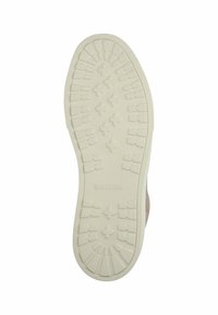 Gummisål i off-white med teksturerede grebsmønstre og spids tå. Har mærkenavnet "BLACKSTONE" præget.