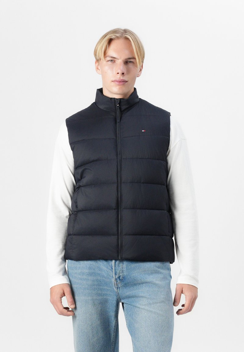 Jūras spēku izlīdzināts veste ar augstu apkakli un priekšējo rāvējslēdzēju, ar nelielu logotipa akcentu. Tiek valkāta pār baltu garām piedurknēm T-kreklu, apvienota ar gaišām džinsām.