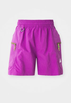 Bright purple outdoor shorts with elastic waistband, two zipped side pockets with green cactus zipper pulls, and a small silver carabiner on left hip.