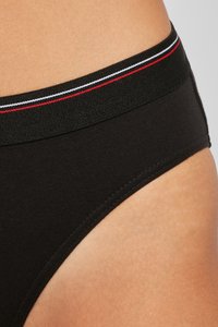 Boxers de algodón negros con una cinturilla texturizada que presenta rayas rojas, blancas y azules, mostrando un diseño liso y ajustado.