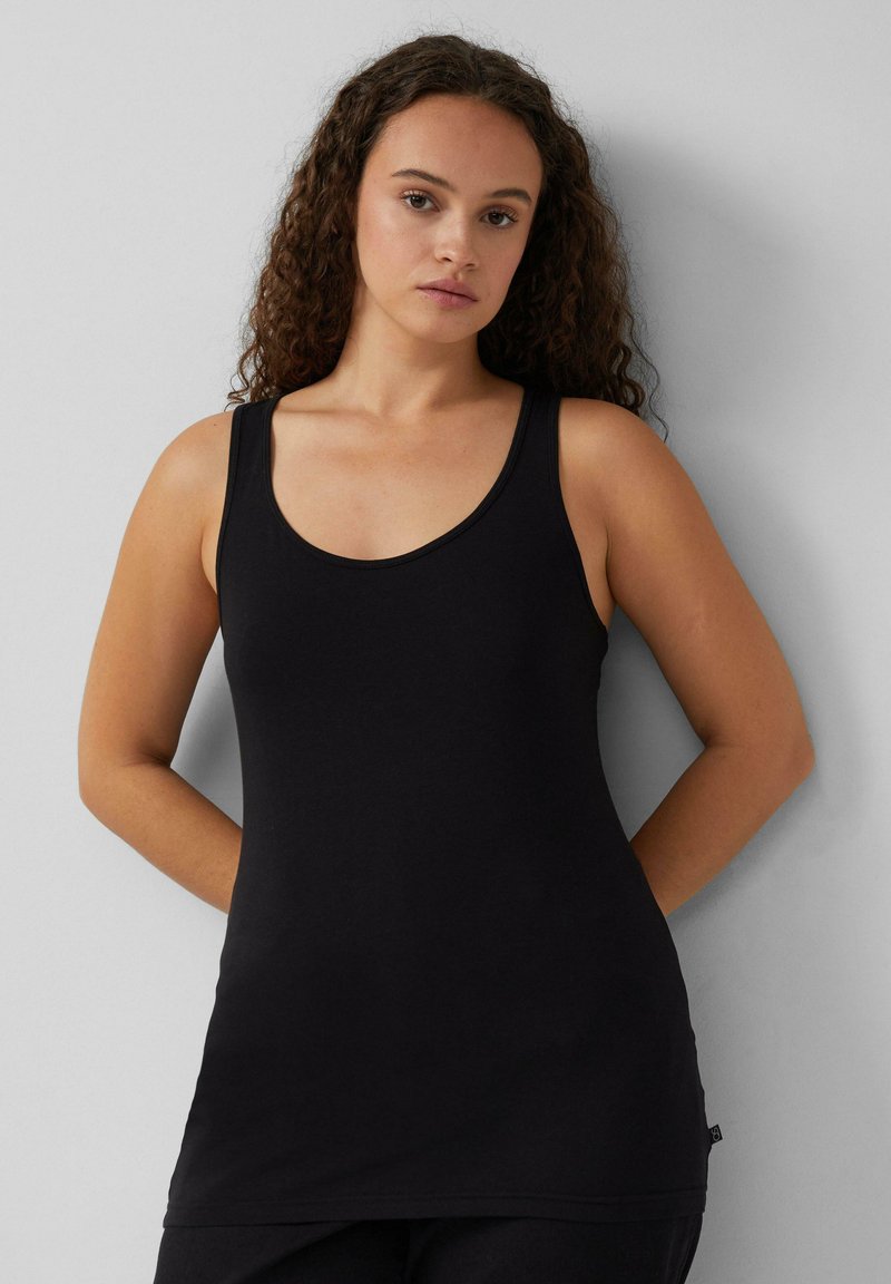Zwarte tanktop met brede bandjes, gemaakt van glad katoen, met een ronde hals en een ontspannen pasvorm. Kleine labeldetail aan de onderrand.