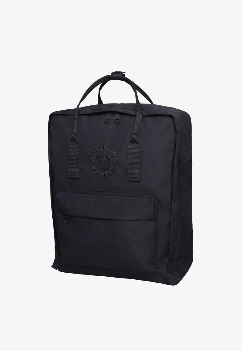 Mochila negra hecha de un tejido duradero con forma rectangular, asas en la parte superior, bolsillo frontal con cremallera y detalle de logo en relieve.