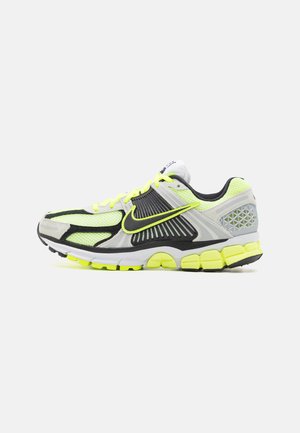 Nike Laufschuh mit einem grauen und schwarzen Mesh-Obermaterial, neon-gelben Akzenten, gepolsterter Sohle und strukturiertem Fersenbereich.